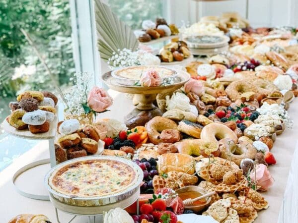 A beautifully arranged table with assorted pastries, sweets, and fruits.