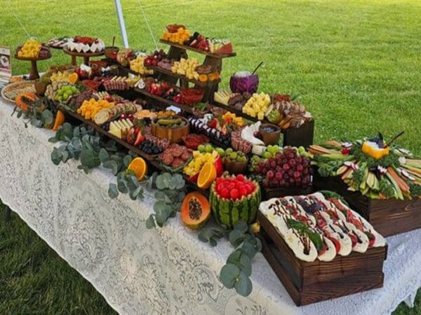 A colorful fruit and dessert display on a table outdoors.