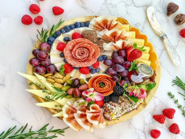 Elegant charcuterie board with fruits, meats, and cheeses arranged beautifully.