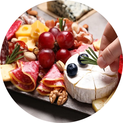 A charcuterie board with grapes, cheese, nuts, and cured meats.