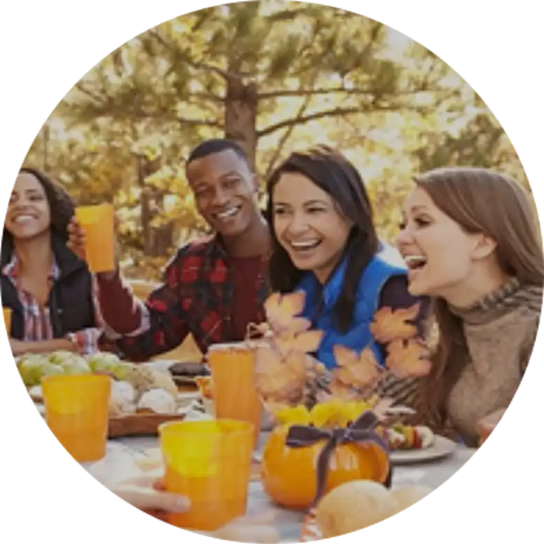 Friends enjoying a cheerful autumn meal together outdoors.