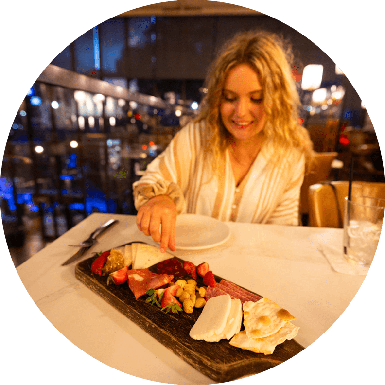 Woman enjoying charcuterie board in restaurant