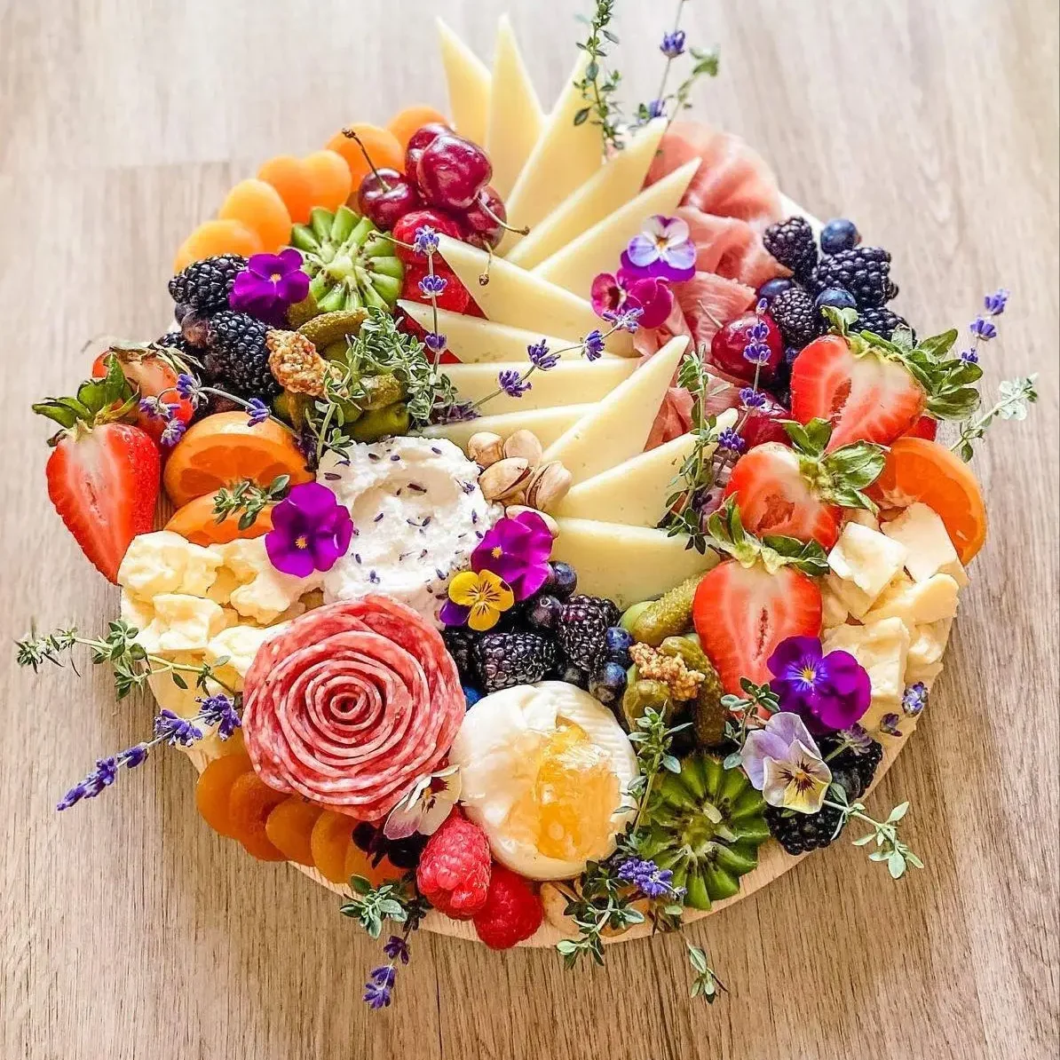 Elegant cheese and flower platter with vibrant colors.